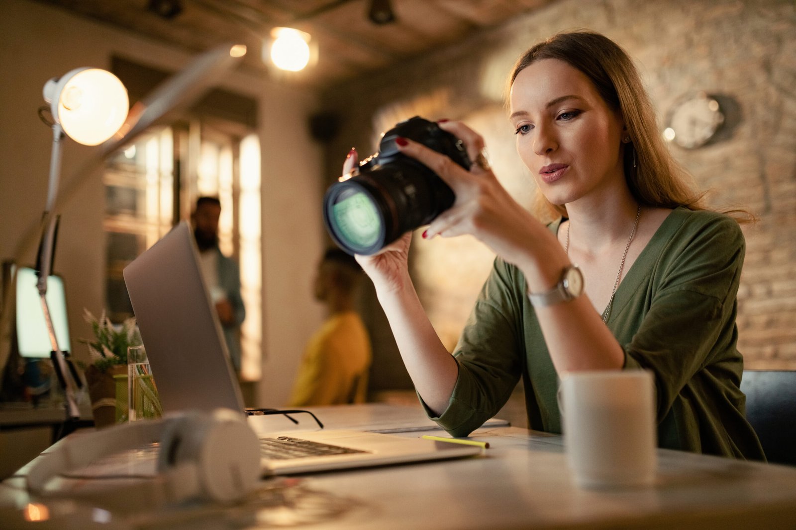 Home female photographer checking images on digital camera in a studi
